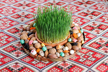 Traditional Azerbaijan holiday Novruz background with green semeni,traditional azerbaijan sweets,shekerbura,qogal,paxlava,mutaki and different nuts and sweets,top view,space for copy