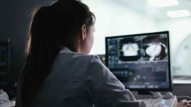 In Control Room Doctor, Radiologist Watching Diagnosis. Hantavirus concept. Procedure and Monitors Showing Brain Scans Results, In the Background Patient Undergoes MRI or CT Scan Procedure. 