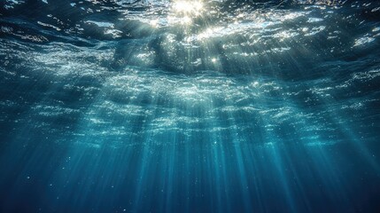 Fototapeta premium Sunbeams penetrate deep ocean water creating a mystical scene
