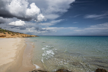 The beautiful beach of Pinus with fine sand and blue and turquoise water and storm clouds on the horizon