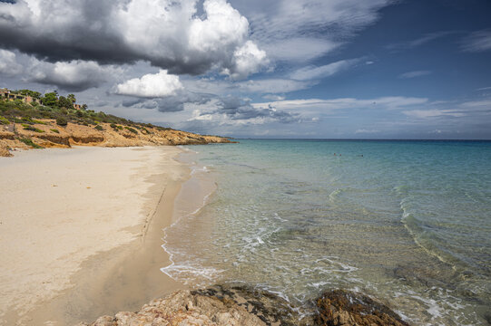 The beautiful beach of Pinus with fine sand and blue and turquoise water and storm clouds on the horizon