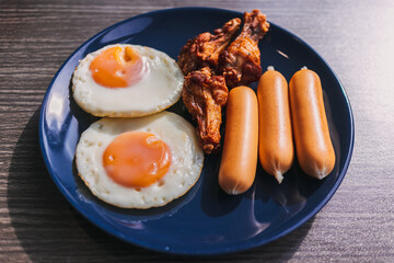 Breakfast set of Fried eggs, sausage and fried chicken wing.