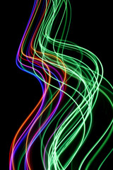A long exposure photograph. Light painting photography, vibrant rainbow colour fairy lights against a black background