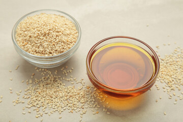 Sesame seeds and sesame oil on light background