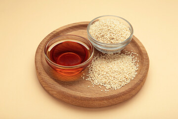 Sesame seeds and sesame oil on beige background