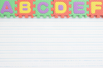 ABC puzzle pieces on lined paper background