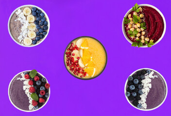 Smoothie with fruits  and berries in the bowls on a purple background. Top view. Healthy food.