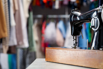 Vintage sewing machine with thread on table in workshop, space for text