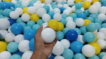 Colorful Ball Pit with a Hand Holding a Ball