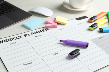 Timetable. Weekly planner, stationery and laptop on white table, closeup