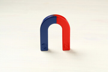 One horseshoe magnet on white wooden table