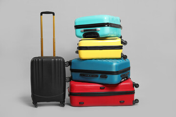 Many closed colorful suitcases on grey background