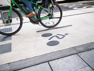 Electric bicycle on bike lane whit painted sign on the ground and bus lane on the background. Ecologic transport in city concept.