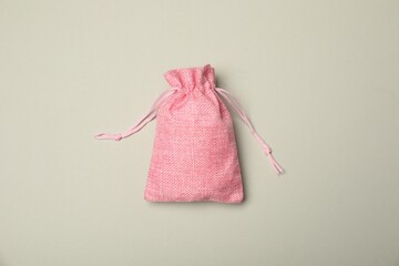 Pink burlap sack on light gray background, top view
