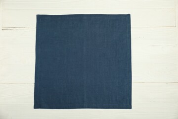 Dark blue napkin on white wooden table, top view