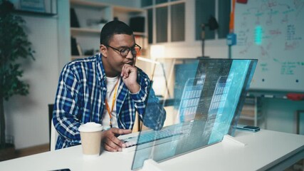 Focused IT developer works with programming code on a futuristic computer screen - Powered by Adobe