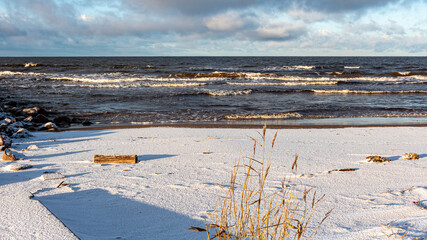 landscape with the seashore, windy winter day, water splashes, icy stones on the seashore, Baltic...