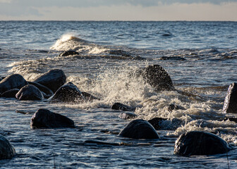 landscape with the seashore, windy winter day, water splashes, icy stones on the seashore, Baltic...