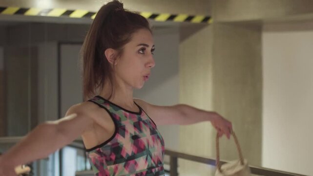 Fit girl exercising with wooden weights in fitness center. Abstract side view..