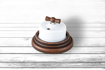 Close-up of a vintage electrical switch on a white wood background
