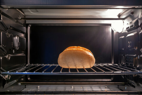 Kleiner Backofen mit einem Br&ouml;tchen und Sicht auf die Heizelemente