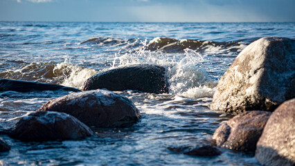 landscape with the seashore, windy winter day, water splashes, icy stones on the seashore, Baltic...