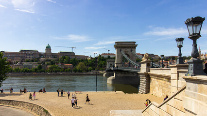 Chain Bridge with lion statues spanning the Danube River, with Buda Castle and Matthias Church in the background in Budapest, Hungary.