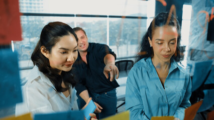 Portrait of professional diverse business team brainstorming marketing idea on colorful sticky...