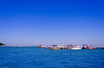 Obraz premium Light blue sea waves and Boats on clean sandy beach, Tropical white sand beach and soft sunshine background, South, Thailand.