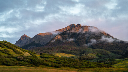 Peaceful Mountain Landscape with Rolling Hills and Clouds During Sunset