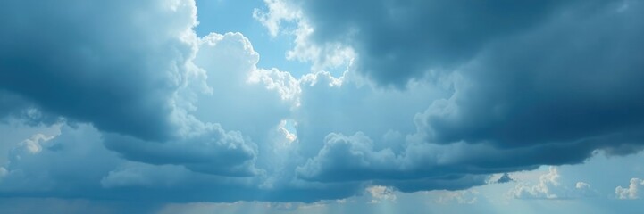 Fototapeta premium Cloudy sky with dark gray clouds dominating the blue horizon, blue horizon, dark gray clouds