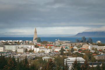 Panoramic view of Reykjavík featuring Hallgrímskirkja church, colorful houses, and Faxaflói Bay with Akranes in the distant background