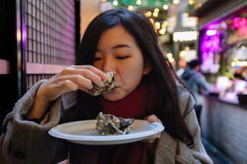 Young woman enjoying fresh oysters at borough market london