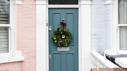 Christmas wreath hanging on a pastel blue door of a london house