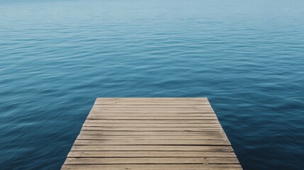 Fototapeta premium Small wooden dock extending over calm blue water.