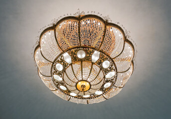Large golden chandelier hanging from a ceiling.