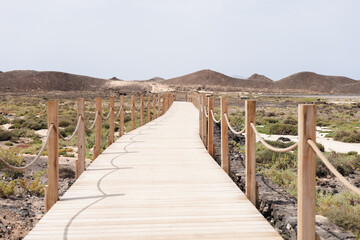 Obraz premium Discover the scenic wooden pathway leading to Isla de Lobos in Fuerteventura