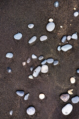 Vibrant stones scattered on the black sand of Fuerteventura's beaches during a sunny afternoon