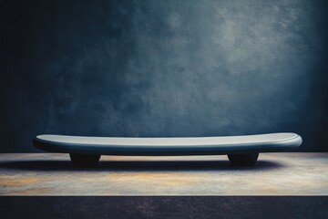 Sleek modern balance board on a textured surface against a dark backdrop