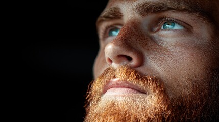 Obraz premium A man with a red beard and blue eyes looking up