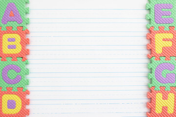 ABC puzzle pieces on lined paper background