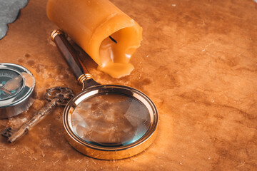 Magnifying glass, key, compass and candle on background old paper. Concept of travel.