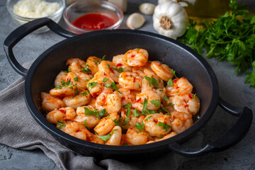 Delicious seafood, grilled shrimps - Shrimps in garlic butter sauce with lemon and parsley sprinkled in a frying pan