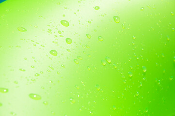 Green background with water drop. Inflatable ring wet in swimming pool. Summer vacation at poolside. Green color of wet background. Drop of water on green inflatable ring in pool. Bright green