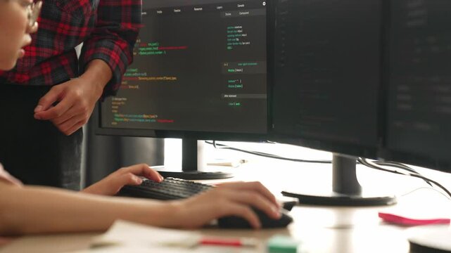 Slow motion back end or software developer manager supervising his team on new application program development on debugging and solving complex code algorithms on monitor. Burgeoning