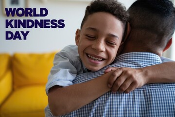 A young boy hugs his father with a smile celebrating World Kindness Day.