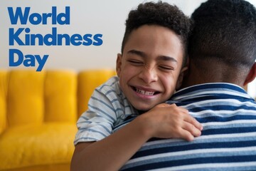 A young boy embraces his father celebrating World Kindness Day.