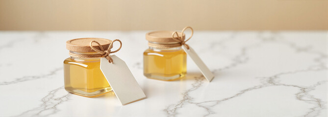 Wedding favor jars with honey on marble background