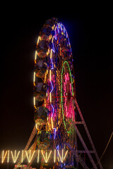 Colourful lit up Ferris wheel in an amusement park and fair during Bodgeshwar Jatra in Mapusa Goa India