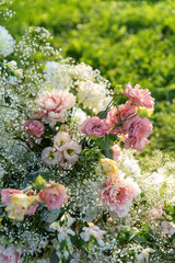 Floral wedding arrangement with pink roses and baby's breath in natural light..